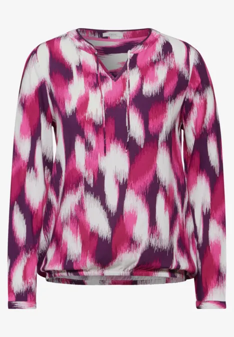 Langarmshirt mit pink-lila Muster und V-Ausschnitt.